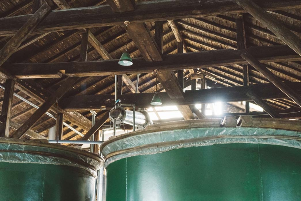木造の天井と大きな緑色のタンク